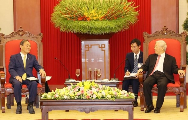 El jefe del Gobierno nipón, Suga Yoshihide, recibido por el secretario general del Partido Comunista y presidente de Vietnam, Nguyen Phu Trong, durante su visita de trabajo en Hanói. (Foto: VNA)