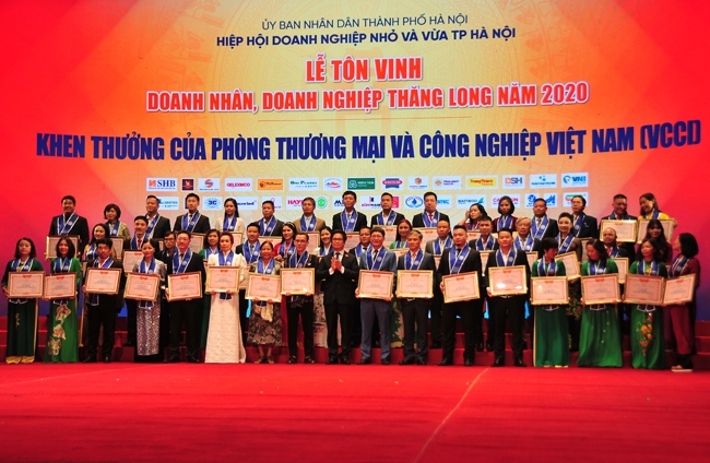 Vu Tien Loc, presidente de la Cámara de Comercio e Industria de Vietnam y presidente del Consejo Central de Asociaciones de Negocios de Vietnam premió a 26 empresas y 25 individuos con excelentes logros en el movimiento de emulación para apoyar la producción y los negocios. Foto: PCV.