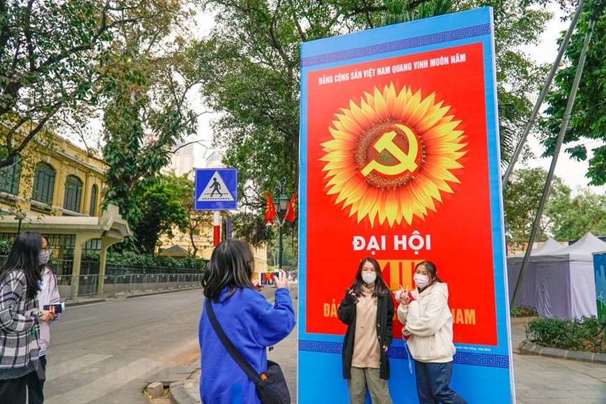 Los jóvenes toman fotos para guardar recuerdos con un gran cartel de bienvenida al próximo XIII Congreso Nacional del Partido Comunista de Vietnam (Fuente: VNA)