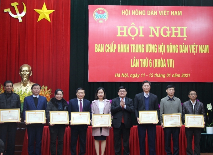 El presidente del comité central de la agrupación, Thao Xuan Sung entrega el certificado de mérito a los individuos sobresalientes en 2020.