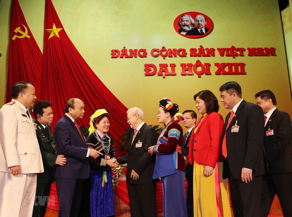 El secretario general del Partido y presidente de Vietnam, Nguyen Phu Trong (quinto desde la izquierda) y el primer ministro Nguyen Xuan Phuc (tercero a la izquierda) saludan a los delegados al XIII Congreso Nacional del PCV. (Foto: VNA)