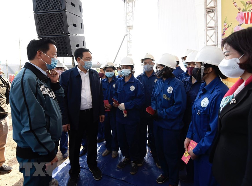 El secretario del Comité del Partido Comunista de la ciudad de Hanói, Vuong Dinh Hue (segundo a la izquierda) y otros delegados visitan a trabajadores de la empresa Cong Vien Cay Xanh (Parques Verdes) de Hanói. (Foto: VNA)