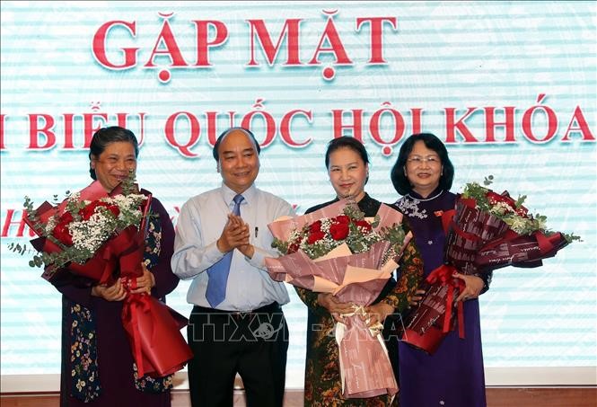 El primer ministro Nguyen Xuan Phuc regala flores a la presidenta de la Asamblea Nacional, Nguyen Thi Kim Ngan ( tercera a la izquierda), la vicetitular del Legislativo, Tong Thi Phong (primera a la izquierda) y la vicepresidenta del Estado, Dang Thi Ngoc Thinh, en una reunión con las diputadas participantes en el noveno período de sesiones de la Asamblea Nacional, XIV legislatura. (Foto: VNA)