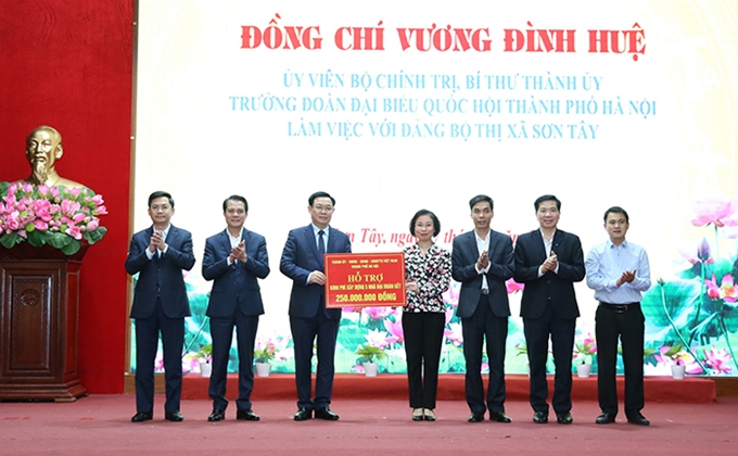Vuong Dinh Hue entrega ayudas financieras para la construcción de viviendas de solidaridad en Son Tay.