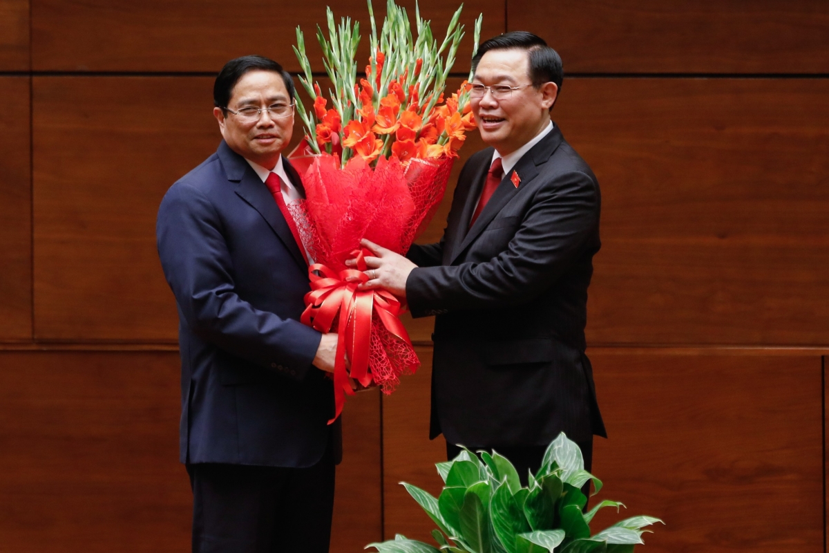 El presidente de la Asamblea Nacional Vuong Dinh Hue (d.) felicita al nuevo jefe del Gobierno Pham Minh Chinh.