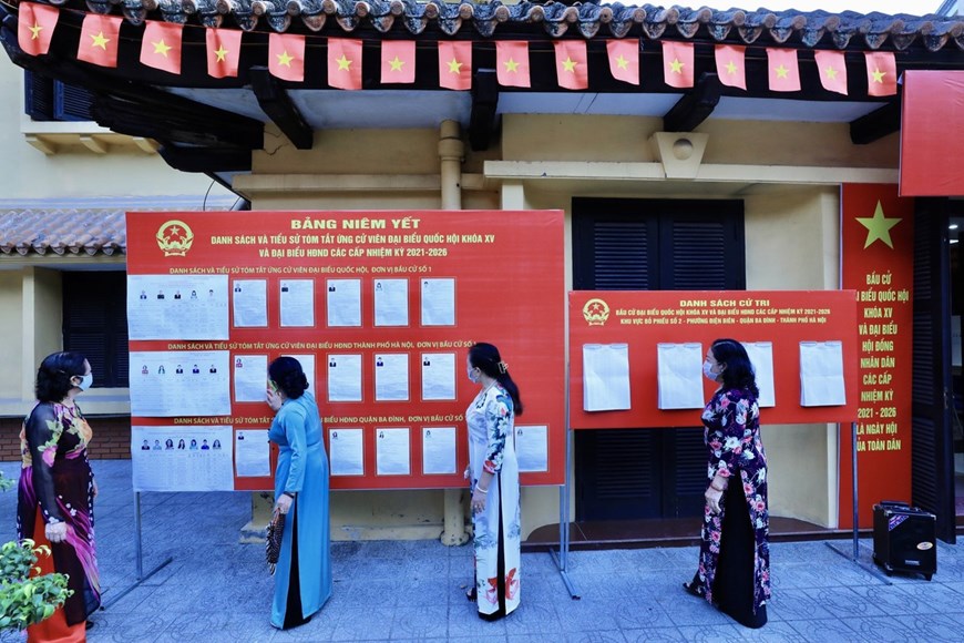 Los electores revisan la lista de candidatos a diputados en el área de votación No. 2, barrio de Dien Bien, distrito de Ba Dinh, Hanoi (Foto: VNA)