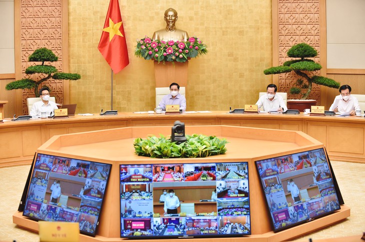 El primer ministro Pham Minh Chinh (segundo a la izquierda) preside una reunión virtual sobre la prevención y el control pandémico. (Foto: VGP)